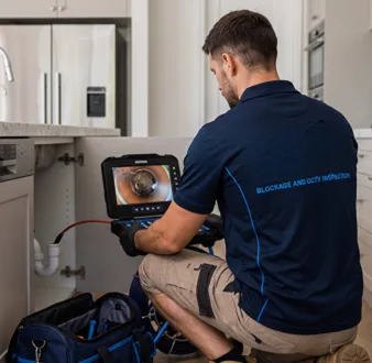 Plumber clearing a blocked toilet in a Hornsby bathroom